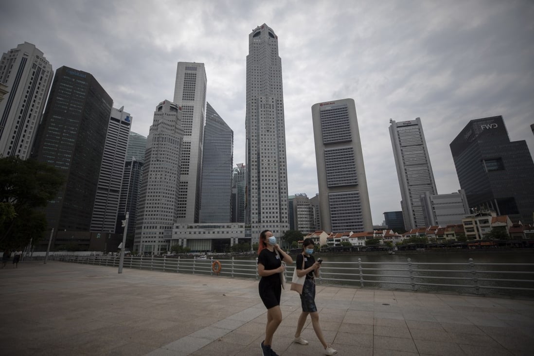 People walk past buildings in the Central Business District of Singapore earlier this month. Photo: EPA