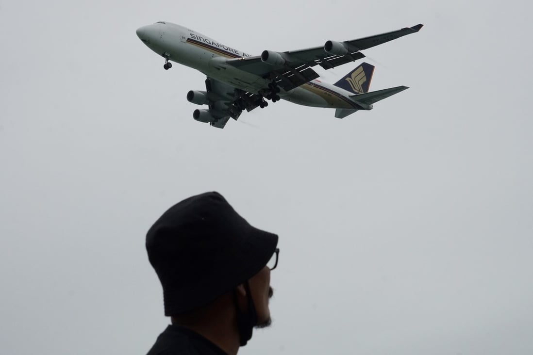A man looks on as a Singapore Airlines plane approaches for landing at Changi International Airport in Singapore. Photo: AFP