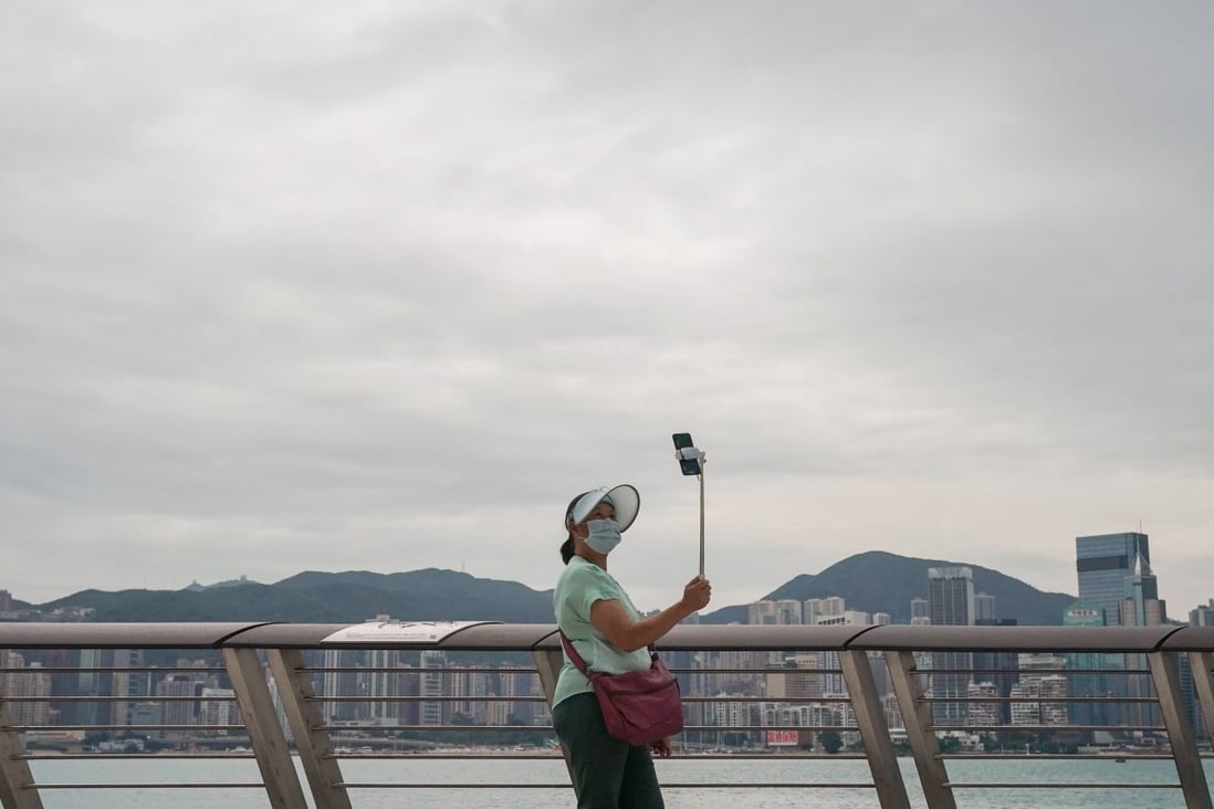 A woman takes selfies at Hong Kong’s waterfront in Tsim Sha Tsui. Photo: Felix Wong