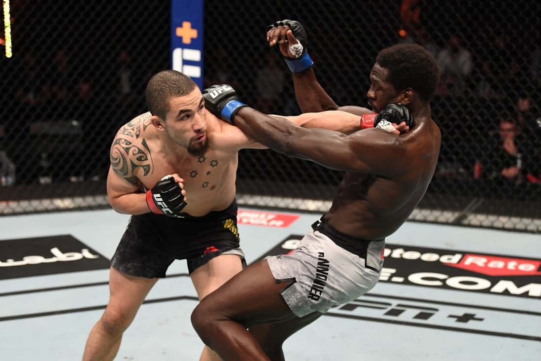 Robert Whittaker punches Jared Cannonier in their middleweight bout at UFC 254 on Fight Island in Abu Dhabi. Photos: Josh Hedges/Zuffa LLC via Getty Images