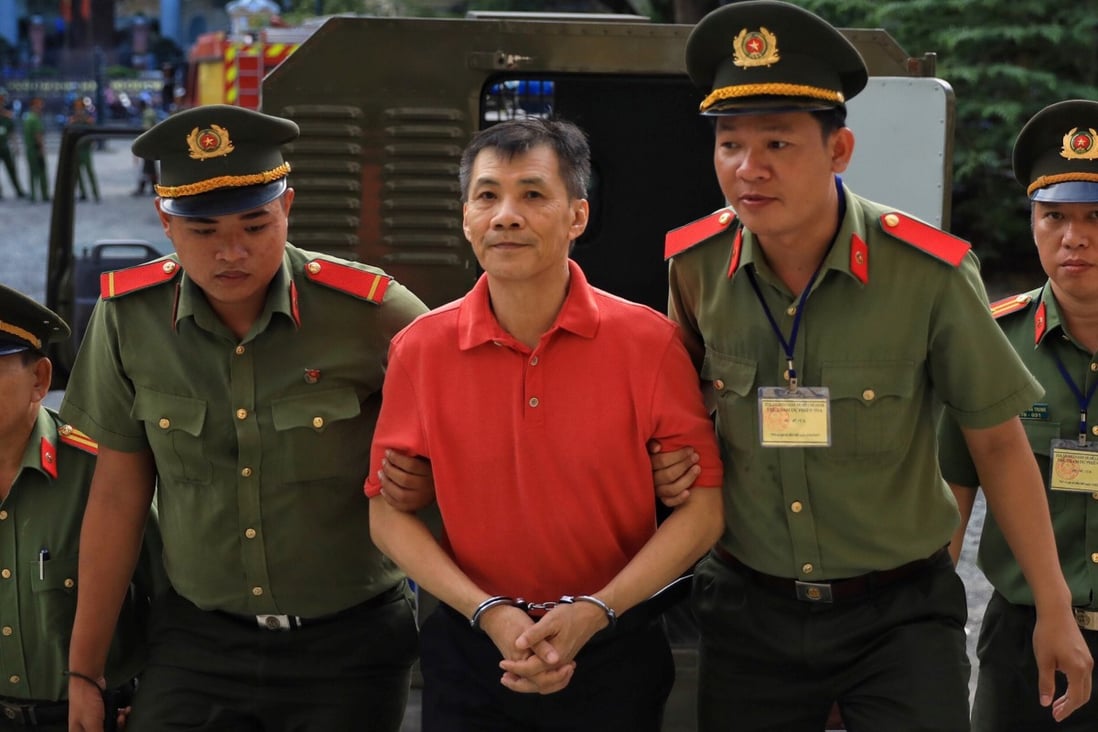 Michael Nguyen is escorted by policemen before his trial in Ho Chi Minh City on June 24, 2019. Photo: Reuters
