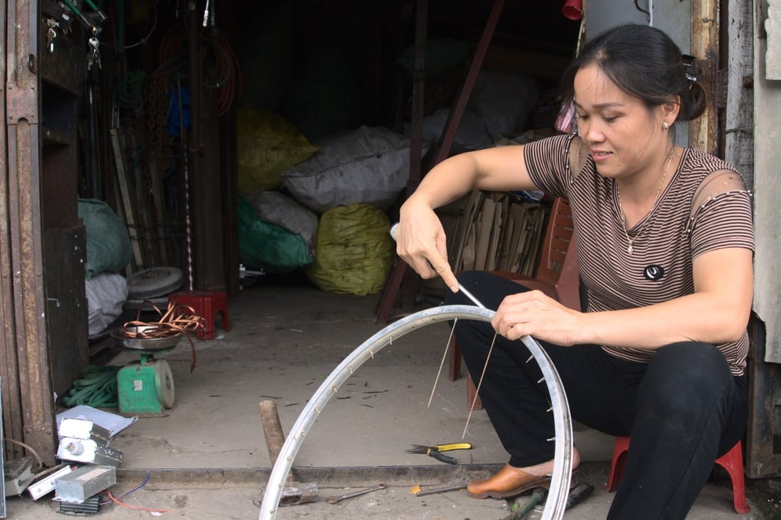 Nguyen Thi Phuong, who runs a collection centre in Hanoi, disassembles an old bicycle wheel to sell on the valuable parts to recyclers. Photo: Sen Nguyen