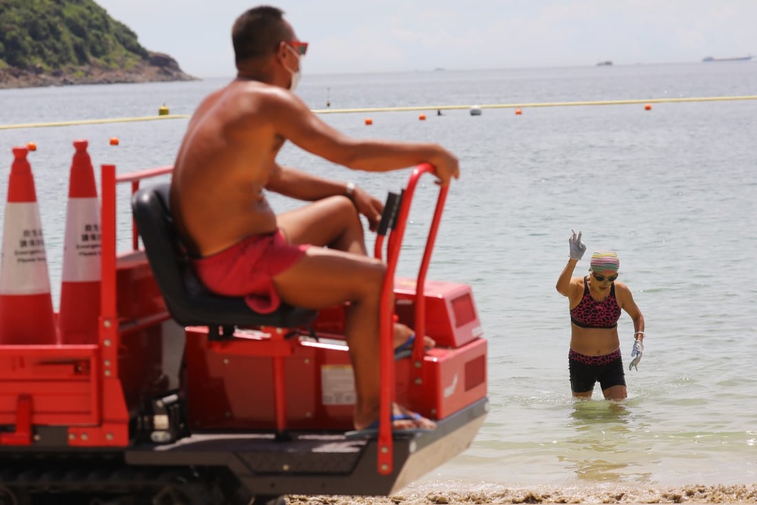 A swimmer comes out of the water as a lifeguard looks on at a beach in Clear Water Bay on July 25. Hong Kong has closed beaches as part of its coronavirus containment measures. Photo: Dickson Lee