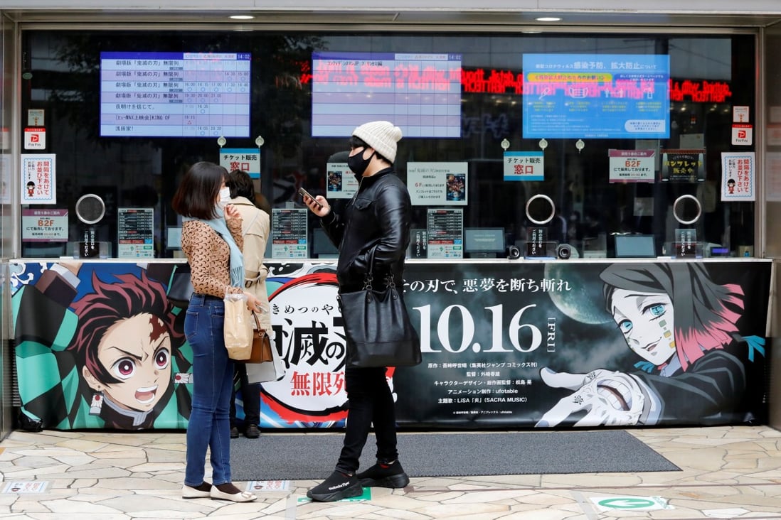 A couple outside a Tokyo cinema waiting to purchase tickets for Demon Slayer. Photo: Reuters