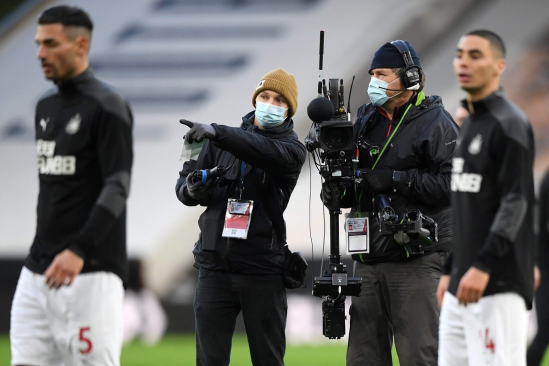 TV camera operators, wearing a face mask or covering due to the Covid-19 pandemic, work as players warm up ahead of the English Premier League football match between Wolverhampton Wanderers and Newcastle United. Photo: AFP