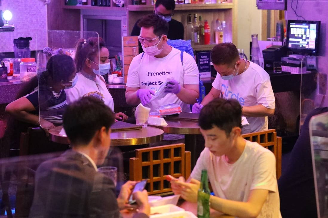 Staff of Hong Kong-based testing agency Prenetics visit Lan Kwai Fong in Central to distribute RT-PCR COVID-19 Test packs to customers at bar and restaurants. Photo: SCMP / Dickson Lee