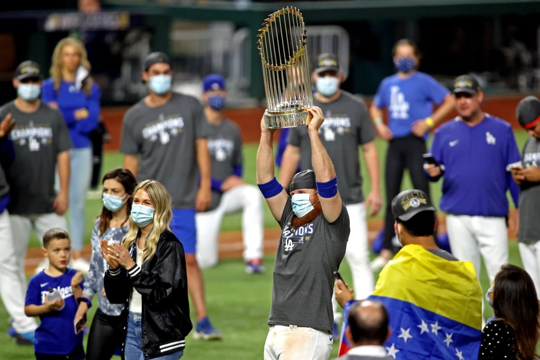 A masked Justin Turner celebrates with the Commissioner’s Trophy after the Los Angeles Dodgers beat the Tampa Bay Rays to win the World Series. Photo: USA TODAY Sports
