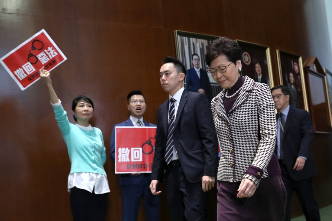Claudia Mo Man-ching and Gary Fan Kwok-wai hold a protest as Carrie Lam Cheng Yuet-ngor walks into Legco Chamber for her question and answer session at Legco in 2019. Photo: Dickson Lee