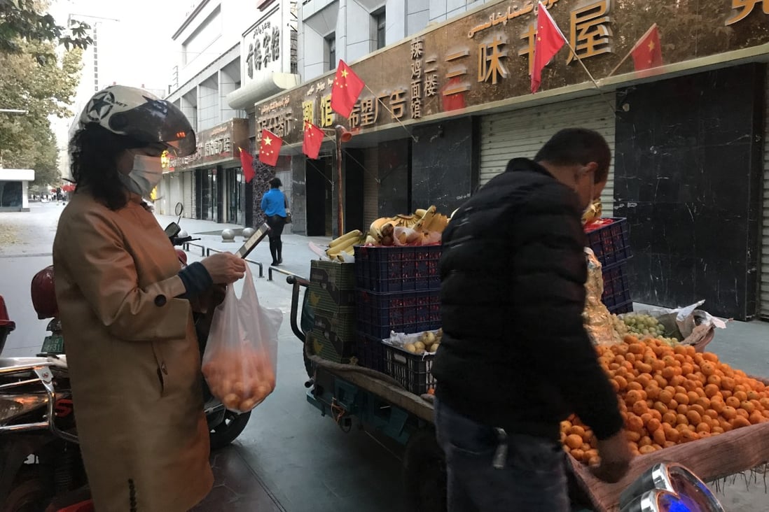 In Kashgar, only essential workers, like this fruit seller, are allowed to leave their residential compounds. Photo: Qin Chen