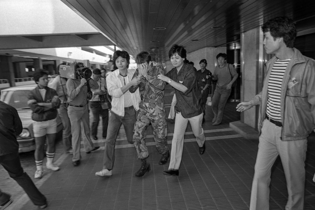 One of the two soldiers is escorted from Kai Tak airport after surrendering to police. Photo: SCMP