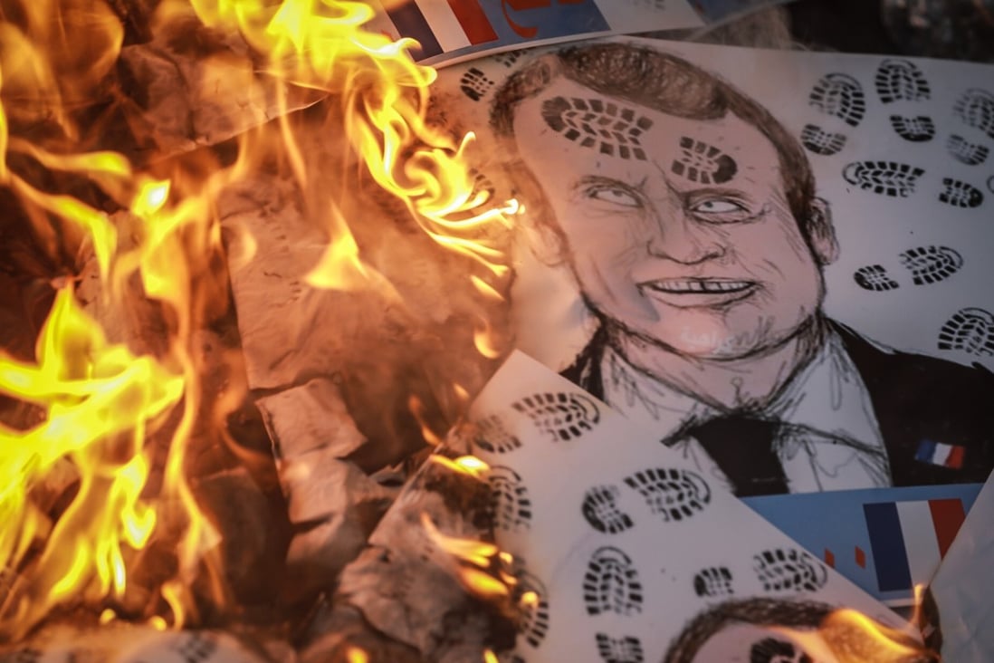 Pictures depicting French President Emmanuel Macron are set on fire during a protest in Baghdad. Photo: dpa