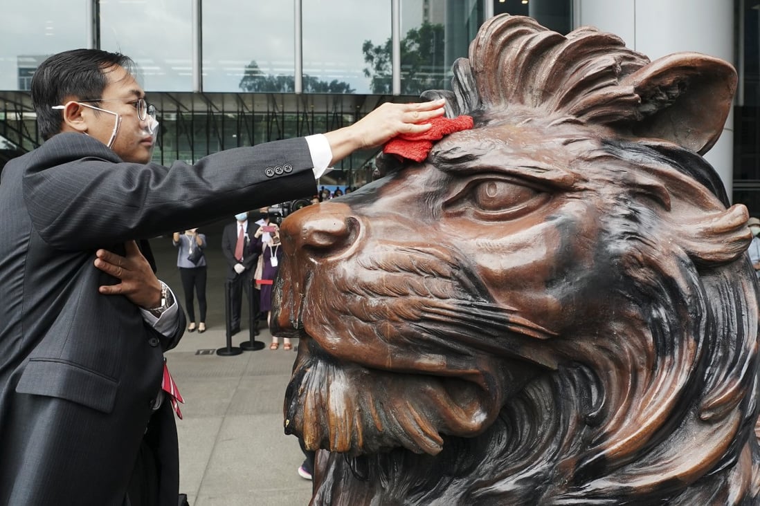 A staff member cleans one of HSBC’s historic lion sculptures ahead of their unveiling outside the bank’s headquarters in Central on October 22. The sculptures were restored after suffering damage during last year’s protests. HSBC has come under increased scrutiny of late amid US sanctions and fears that China might place it on an “unreliable entities” list. Photo: Felix Wong