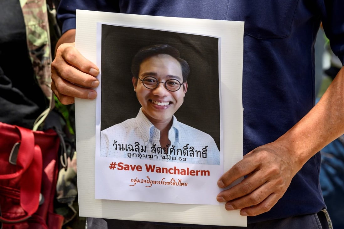 A protester holds a portrait of allegedly kidnapped Thai activist Wanchalerm Satsaksit. Photo: AFP