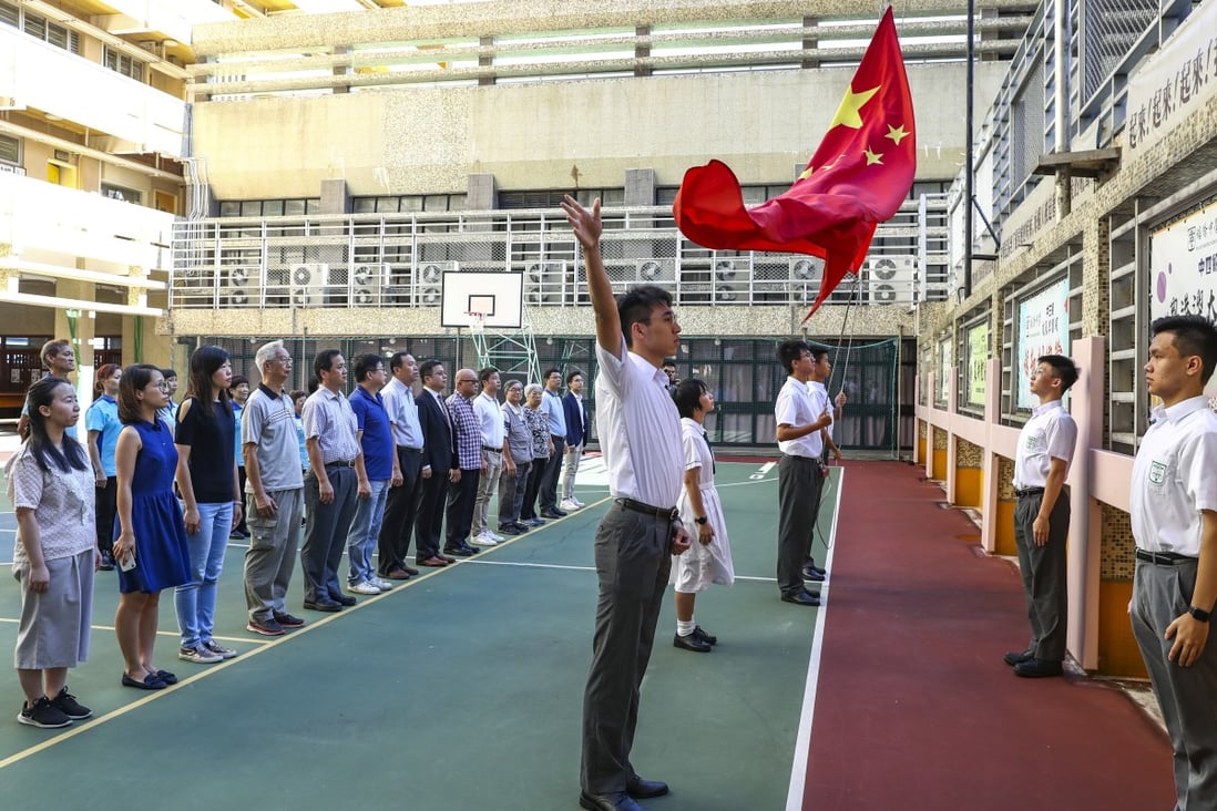 Students from Pui Kiu Middle School in North Point take part in a flag-raising ceremony. Photo: Nora Tam