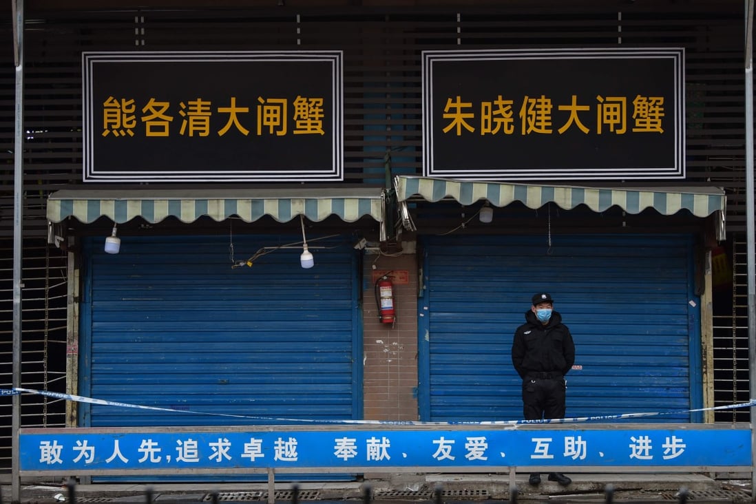 A security guard stands outside the Huanan Seafood Wholesale Market in Wuhan where the coronavirus was detected in January. No date has been announced for the WHO team to go to Wuhan. Photo: AFP