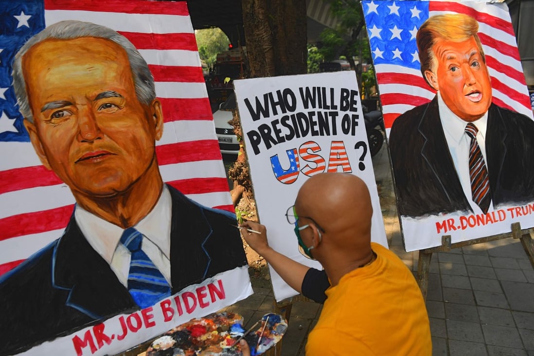 An artist paints an image of Joe Biden next to a painting of US President Donald Trump in Mumbai, India. Photo: AFP