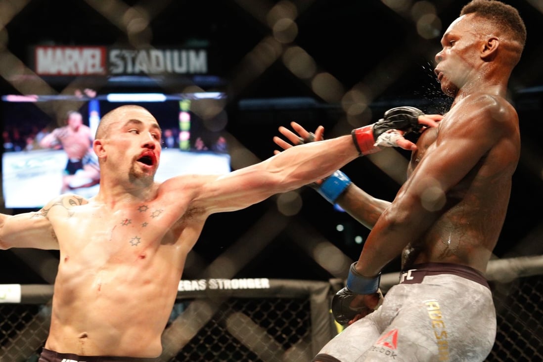 Robert Whittaker punches Israel Adesanya during their middleweight title bout at UFC 243 in Melbourne. Photo: AFP