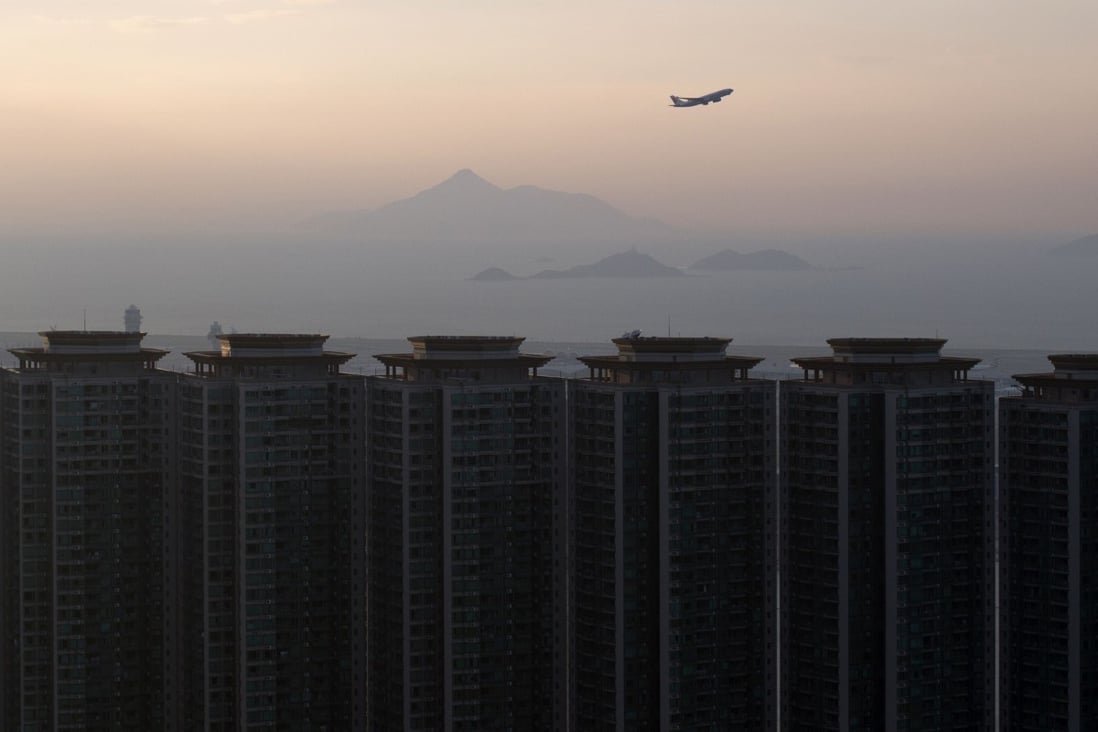 A plane takes off from Hong Kong International Airport with residential buildings in Tung Chung in the foreground. Photo: AFP