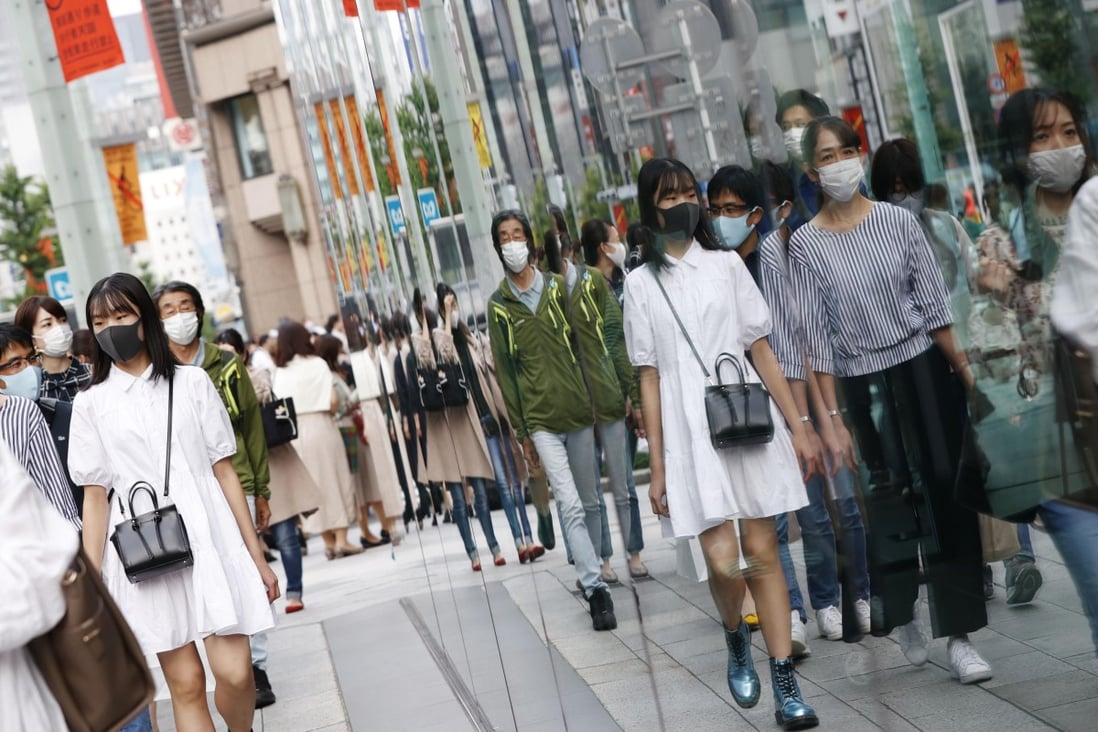 People wearing face masks walk in Tokyo’s Ginza area. An huge drop in foreign nationals arriving in Japan this year has left the luxury retail market reeling. Photo: Kyodo News via Getty Images