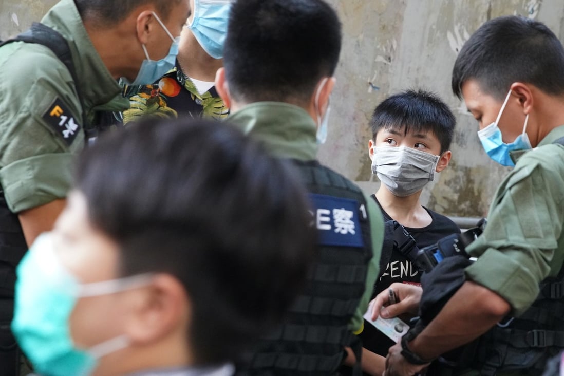 Police officers carry out an ID check on a boy outside Prince Edward MTR station on August 31, as anti-government protesters gathered to mark the first anniversary of the “831” incident. Photo: Winson Wong