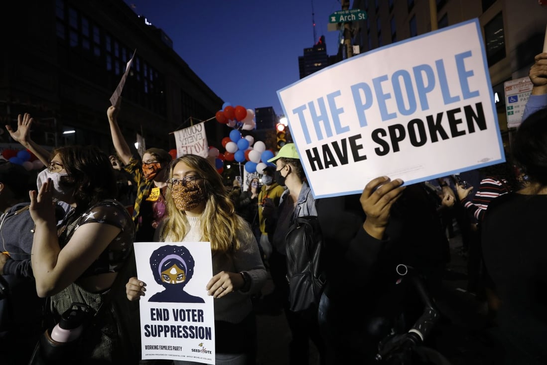Demonstrators stand outside the Pennsylvania Convention Centre where votes are being counted. Two men armed with loaded handguns were arrested near the centre on Thursday. Photo: AP Photo
