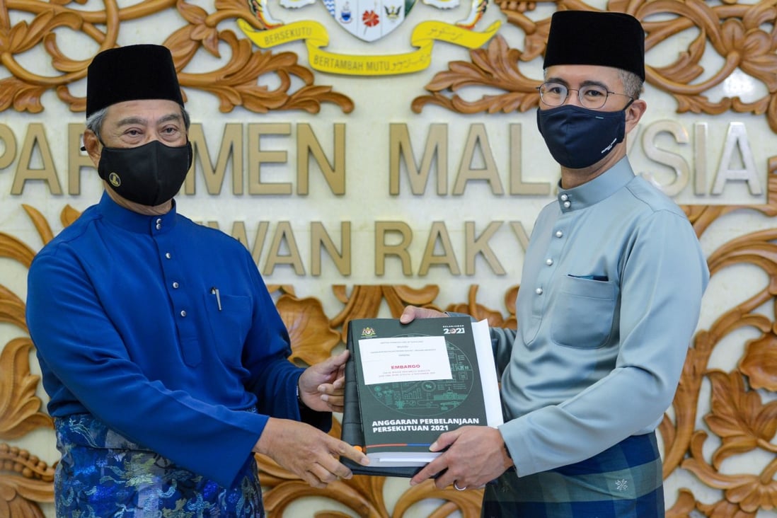 Prime Minister Muhyiddin Yassin (left) and Finance Minister Zafrul Aziz, posing with the national 2021 budget. Photo: AFP