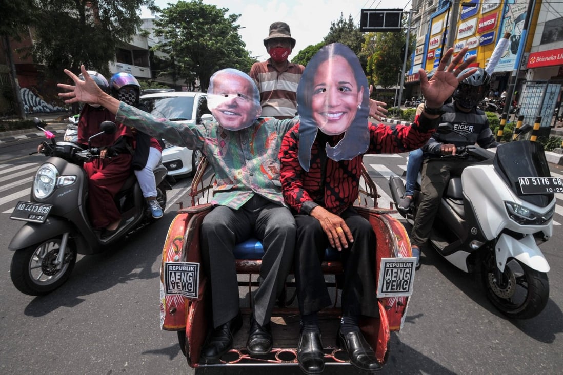 Local residents wearing masks of Joe Biden and Kamala Harris wave as they ride on a trishaw along a street in Solo, central Java, Indonesia. Photo: AFP