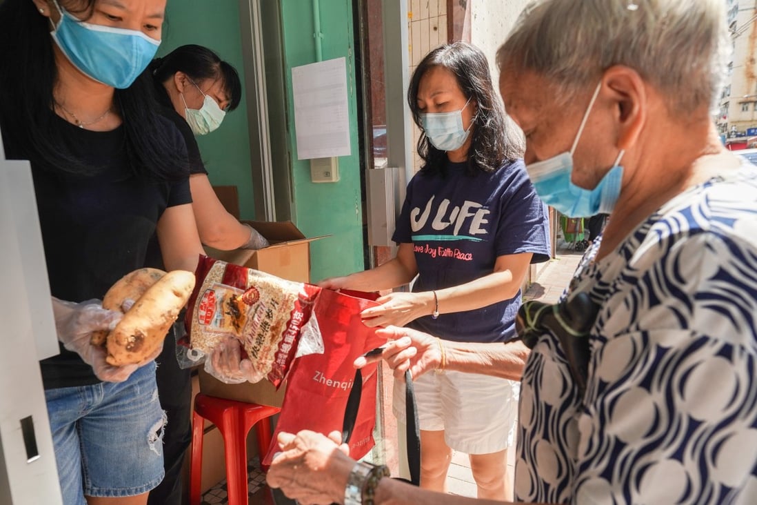 Elderly and the underprivileged receive provisions from a Sham Shui Po food bank coordinated by J Life Foundation Limited. Photo: Felix Wong