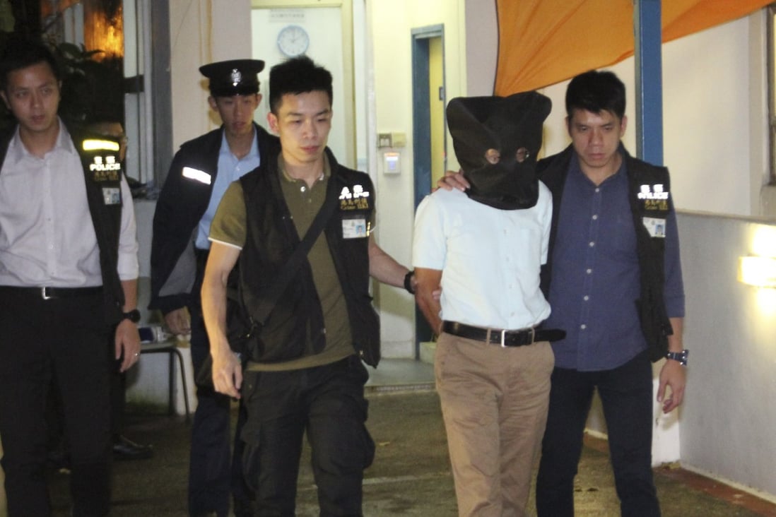 Police lead Cheung Kie-chung away after his wife’s body was found in his university office. Photo: Handout