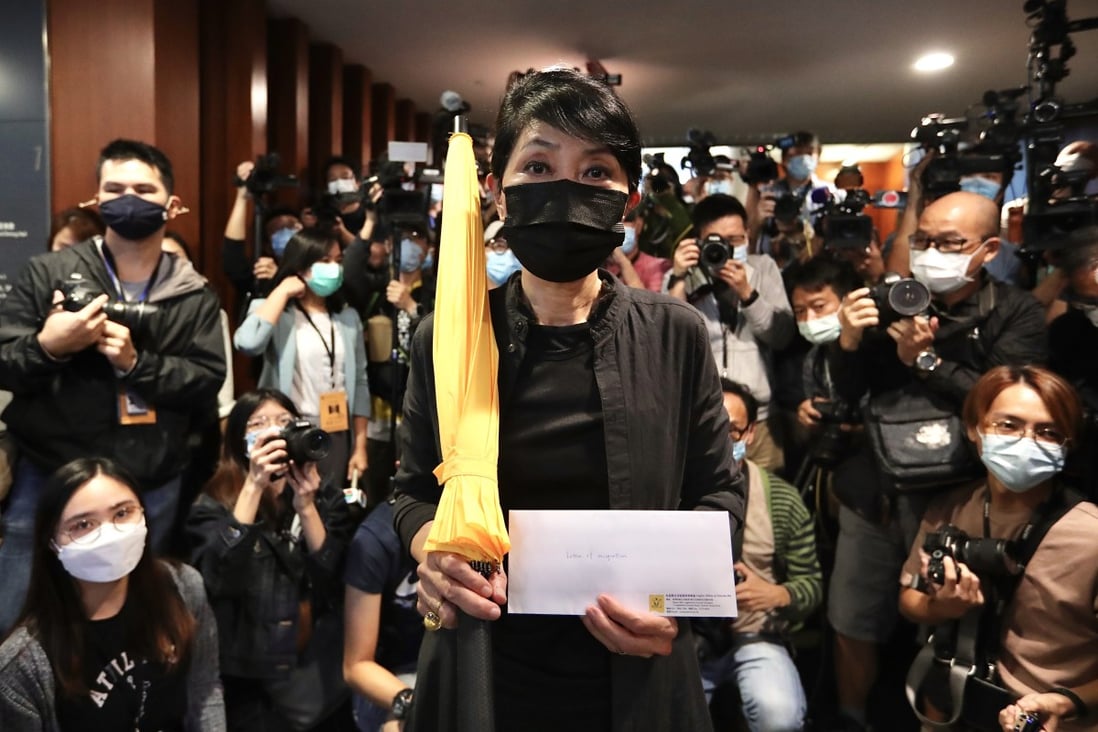 Hong Kong opposition lawmaker Claudia Mo holds a yellow umbrella on her way to hand in her resignation letter in protest over the disqualification of four legislators by China’s National People’s Congress Standing Committee. Photo: dpa