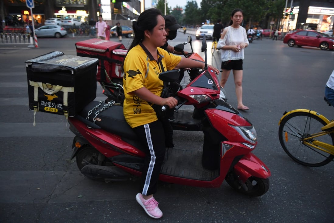 A Meituan delivery rider waits at an intersection in Beijing. Photo: AFP
