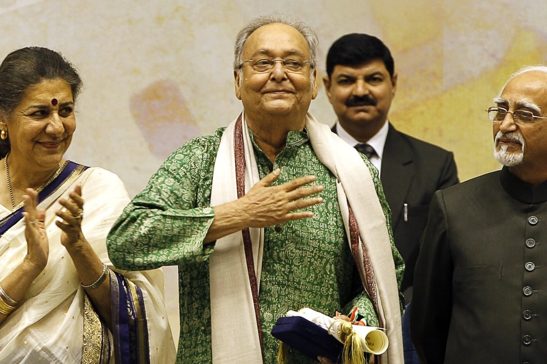 Bengali-language film actor Soumitra Chatterjee, centre, gestures after receiving the Dadasahab Phalke Award from the Indian government in 2012. Photo: AP