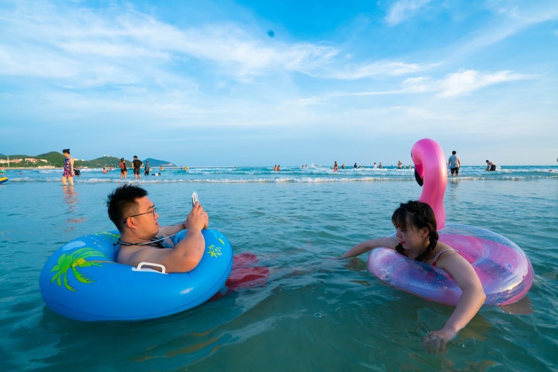 Chinese tourists relax at Dadonghai Bay, in Sanya, China, on August 30. The hotel occupancy rate in Sanya has stood significantly above the average for mainland China since July. Photo: Steven Ribet