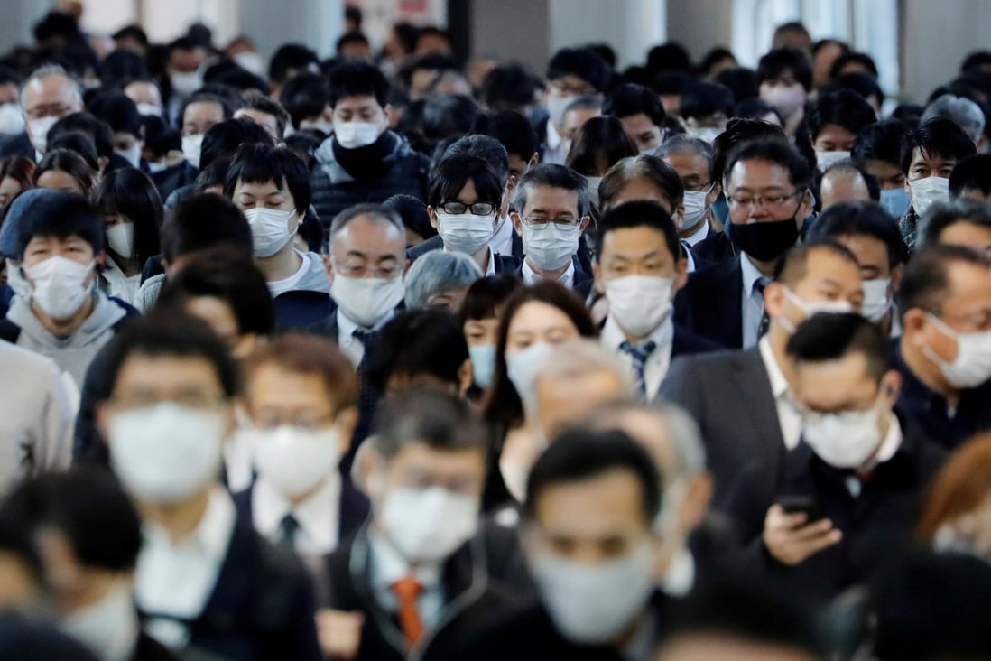 Office workers wearing face masks are seen at Shinagawa station in Tokyo, as the Japanese capital battles an outbreak in Covid-19 cases. Photo: Reuters