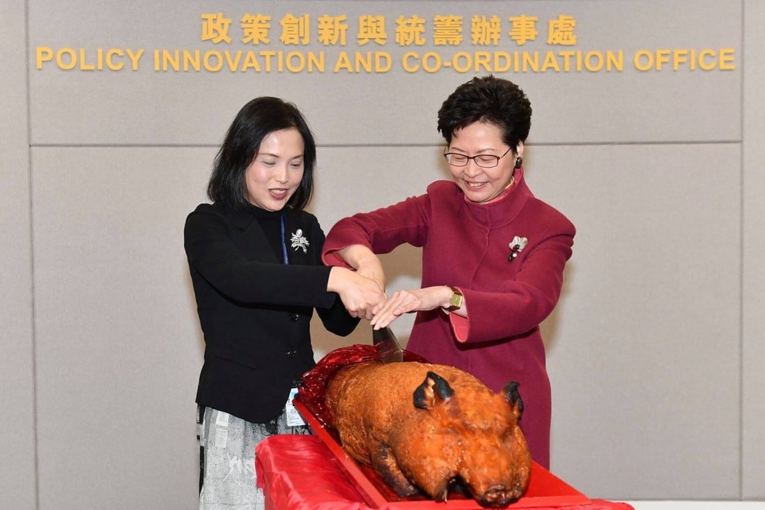Betty Fung and Carrie Lam cut a roast pig to mark the 2018 opening of the Policy Innovation and Coordination Office, which Fung leads. Photo: Facebook