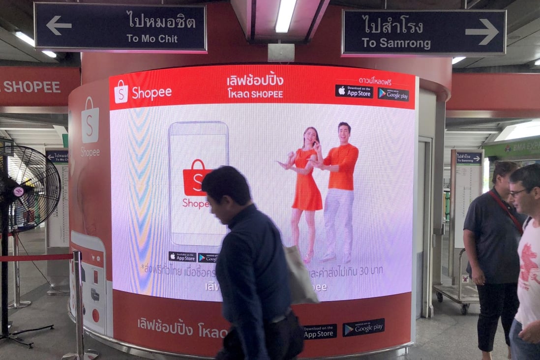 Commuters walk past an advertisement for online commerce site Shopee at a Bangkok skytrain station. Photo: SCMP / Chua Kong Ho