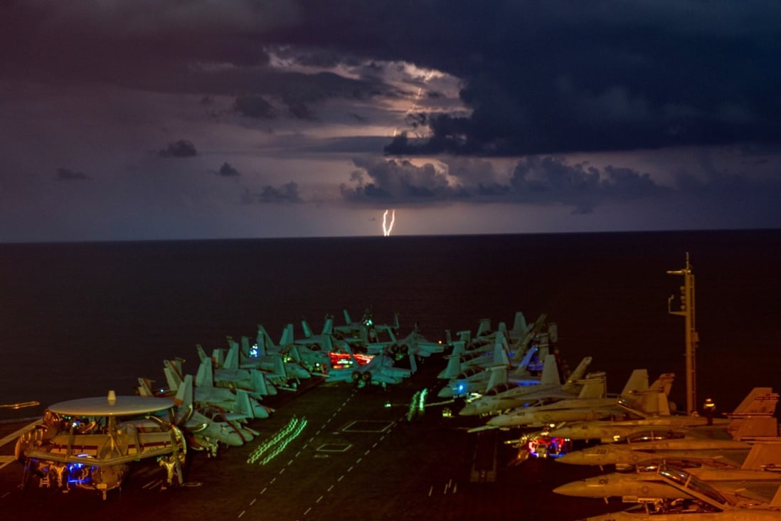Lightning flashes over the US Navy aircraft carrier USS Nimitz as it transits the South China Sea on July 4. Photo: Handout via Reuters