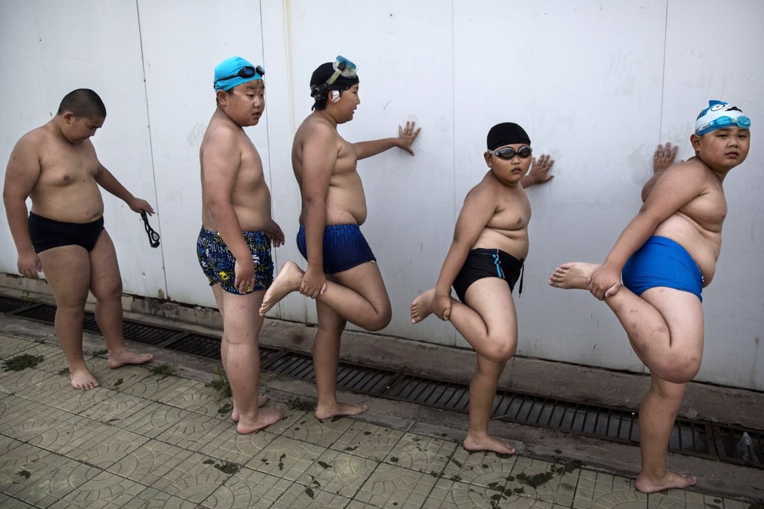 Overweight Chinese students stretch after swimming during training at a camp held for overweight children in Beijing. A change in the national high-school entrance exam may motivate schoolchildren to be more physically active. Credit: Getty Images