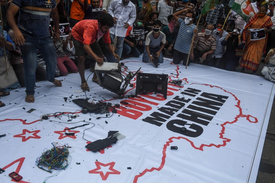 Demonstrators break up Chinese-made goods on a banner with an inscription reading “Boycott Made in China” before burning them during an anti-China demonstration in Kolkata on June 18. Photo: AFP