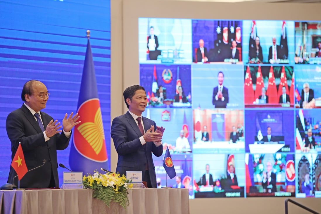 Vietnam’s Prime Minister Nguyen Xuan Phuc (left) and Minister of Industry and Trade Tran Tuan Anh celebrate during the virtual signing ceremony for the Regional Comprehensive Economic Partnership in Hanoi on November 15. Photo: EPA-EFE