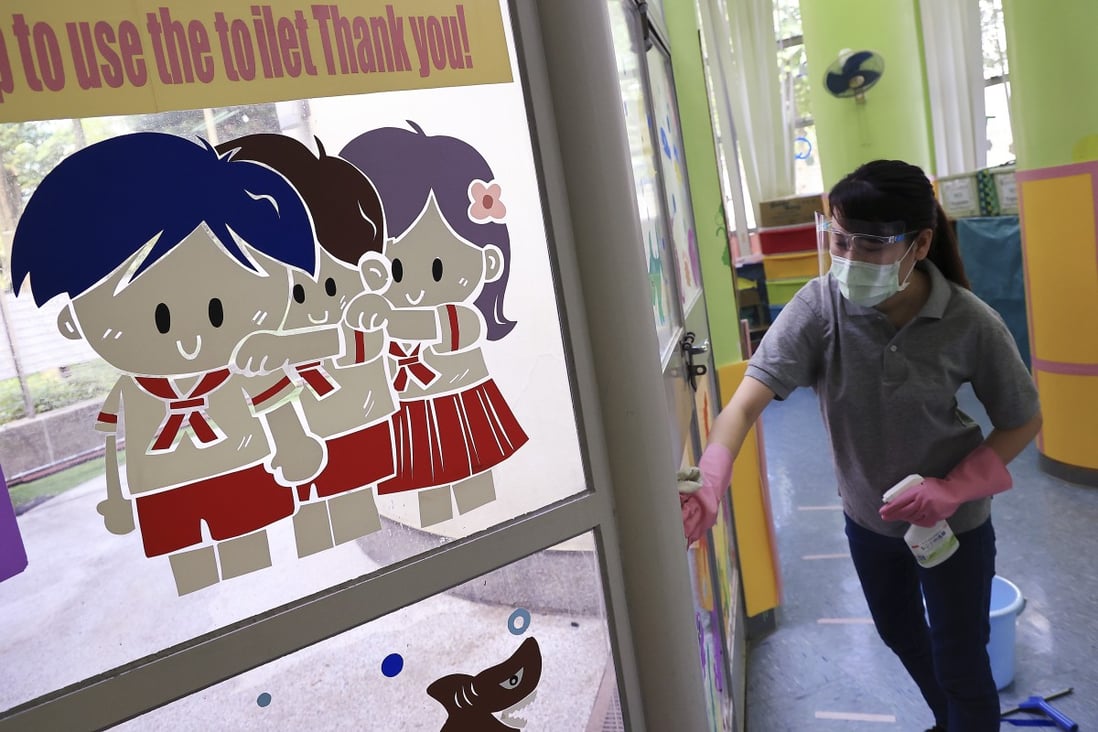 A cleaning worker wipes down the doors and windows at a kindergarten in Tung Chung on November 17, after the government announced the suspension of face-to-face teaching at all kindergartens and daycare centres amid an outbreak of upper respiratory tract infections. Photo: May Tse