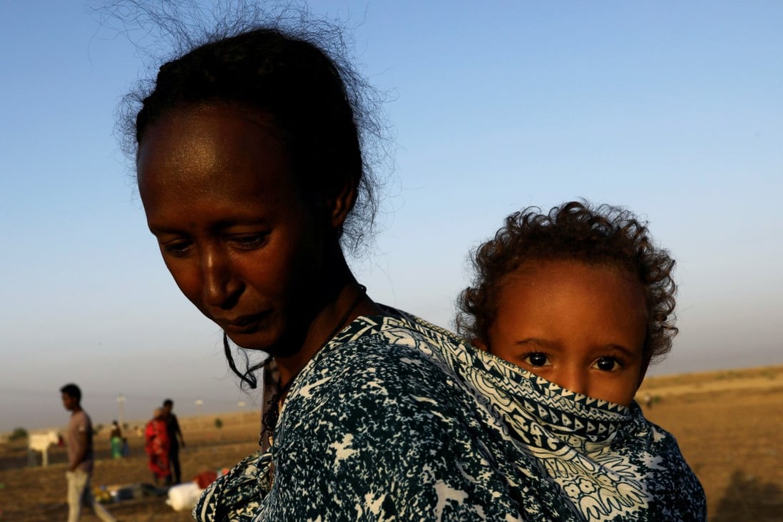 An Ethiopian refugee carries her child near the Setit river on the Sudan-Ethiopia border in Hamdayet village in eastern Kassala state. Photo: Reuters