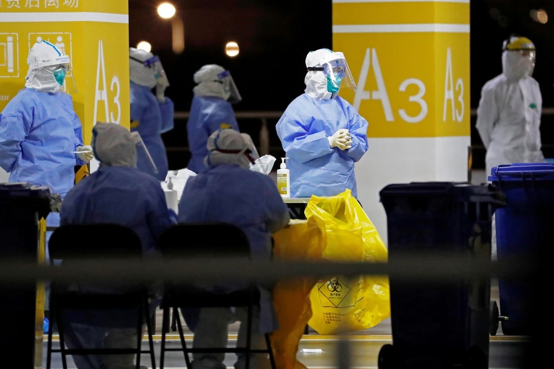 Workers in protective suits staff a makeshift nucleic acid testing site inside a car park at Shanghai Pudong International Airport on Sunday. Photo: CNS Photo via Reuters