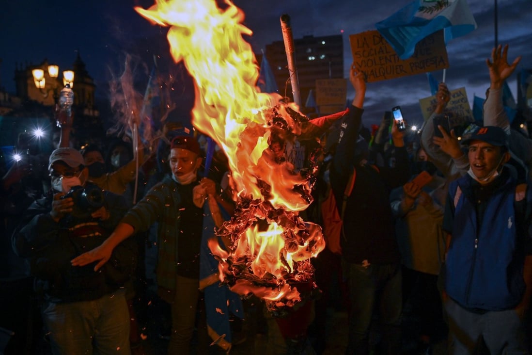 Demonstrators burn an effigy representing Guatemalan President Alejandro Giammattei during a protest demanding his resignation in Guatemala City on Sunday. Photo: AFP