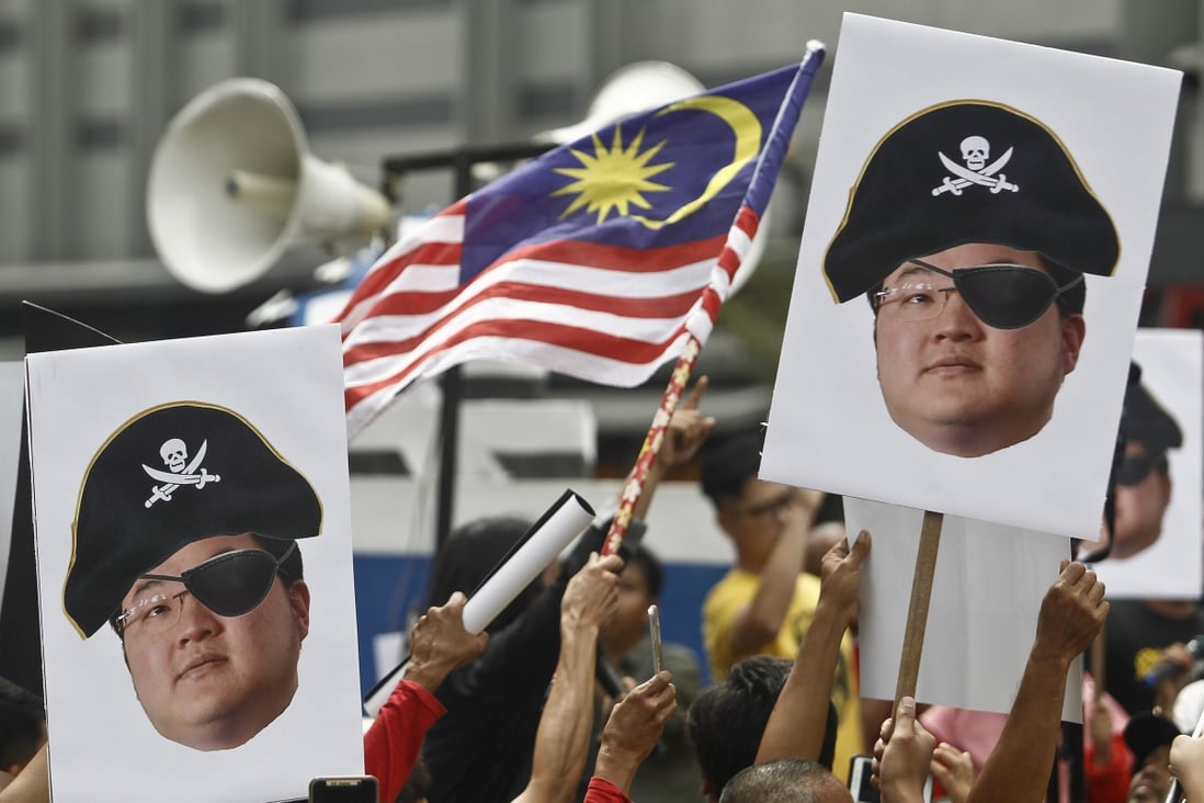 Protesters hold portraits of Jho Low illustrated as a pirate during a rally in Kuala Lumpur, Malaysia, in 2018. Photo: AP