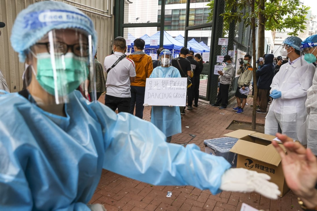 A health worker directs people from dancing groups to a queue at a temporary screening venue in Hong Kong. Photo: Nora Tam