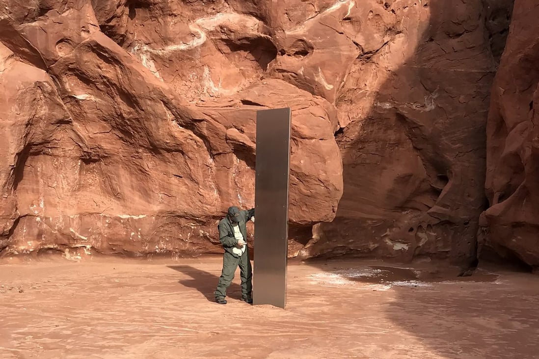 A state worker inspects a metal monolith that was found installed in the ground in a remote area of red rock in Utah on November 18. Photo: Utah Department of Public Safety handout via AP