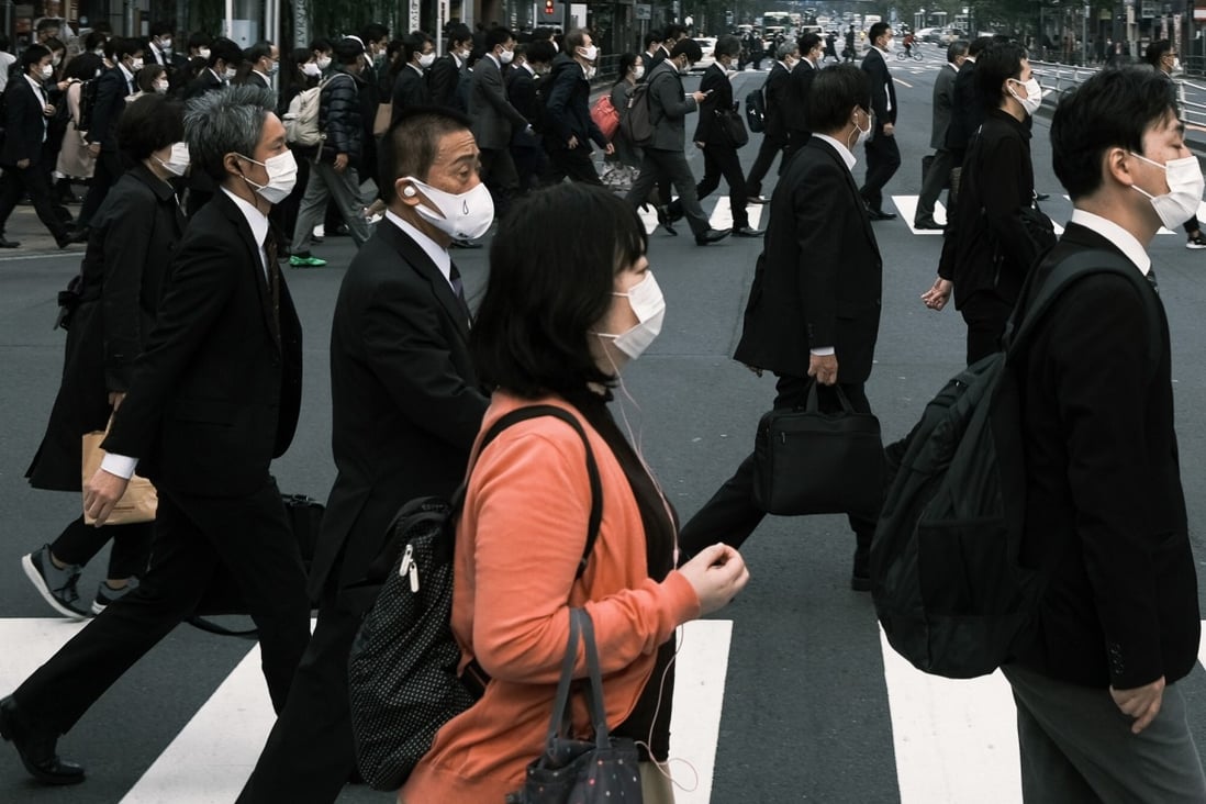 Pedestrians cross a road in Shinbashi, Tokyo. Photo: Bloomberg