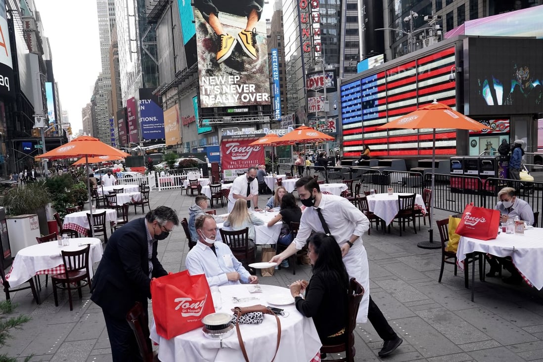 Servers deliver food to a table at a pop-up restaurant set up in Times Square in New York on October 23. Consumer spending accounts for 68 per cent of the US economy. But with Covid-19 still raging, services consumption – restaurant dining, in-person shopping, travel – is unlikely to recover soon. Photo: Reuters