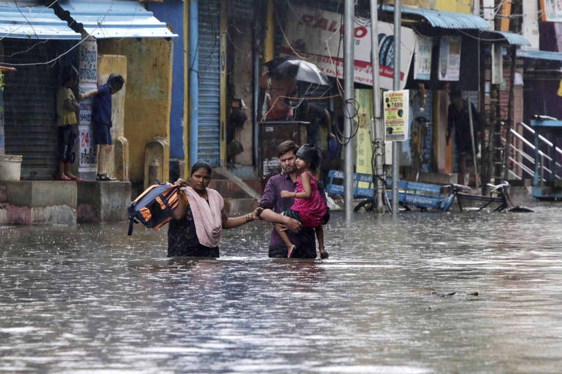 A family wades through a flooded street after Cyclone Nivar made landfall in India’s southern state of Tamil Nadu. Photo: AP